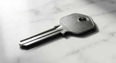 Clé de maison minimaliste sur marbre blanc, symbole de crédit immobilier
